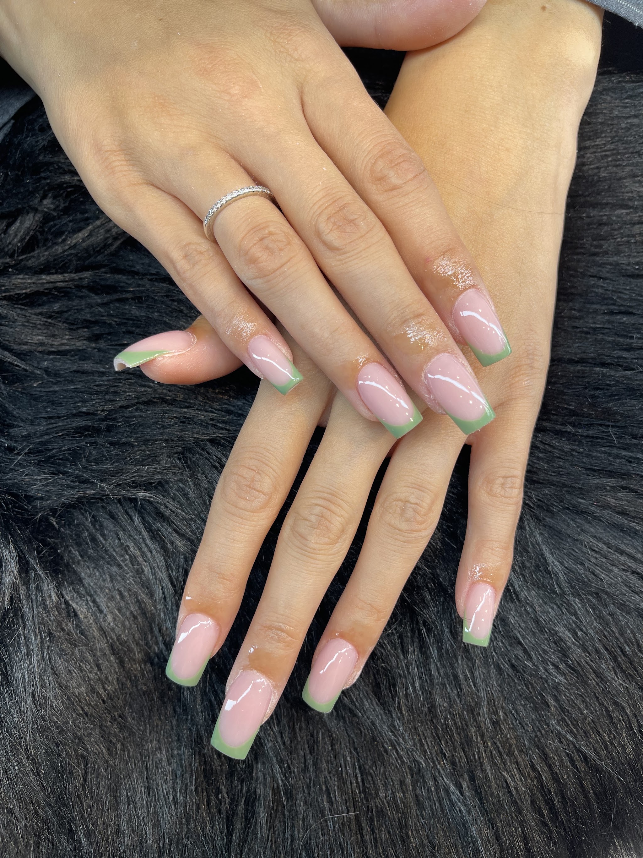 Naturel amandelnagels met een mintgroene French tip, op zwart bont