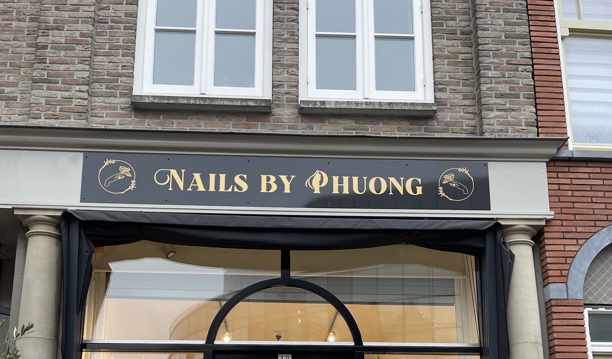 De gevel van Nails by Phuong aan het Waagplein, met het gouden naambord